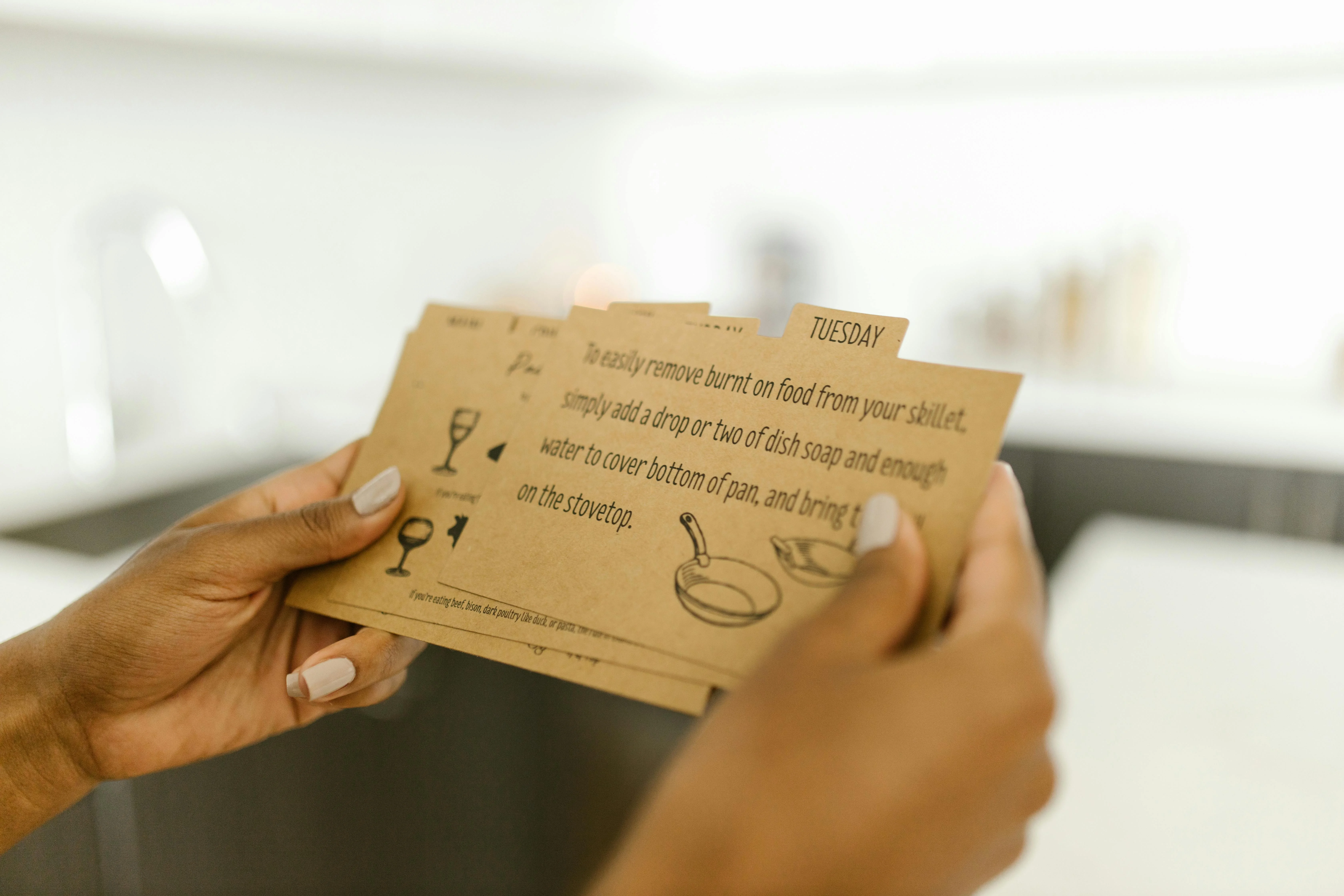 Agent handing MLS printout to a couple in a sunlit living room - close-up on hands and paper